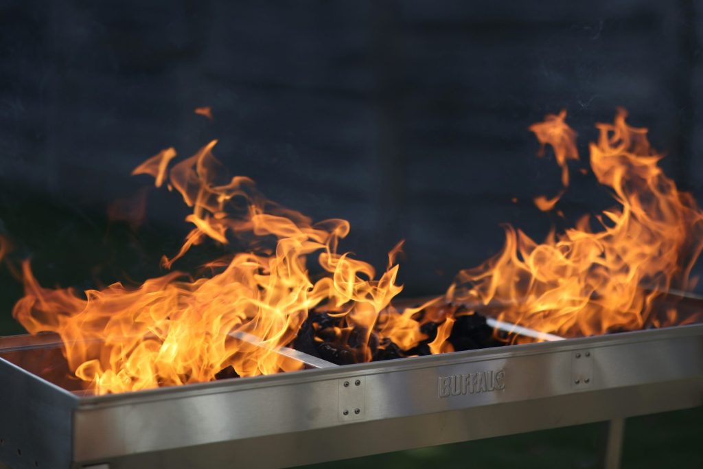 Flammen schlagen aus einem Grill, bereit zum Kochen.